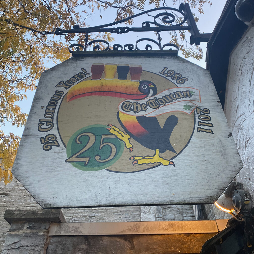 image of a sign for a pub that is called the Toucan. Established in 1986 and the sign marks the 25th anniversary celebrated in 2011. The sign says, 25 glorious years.