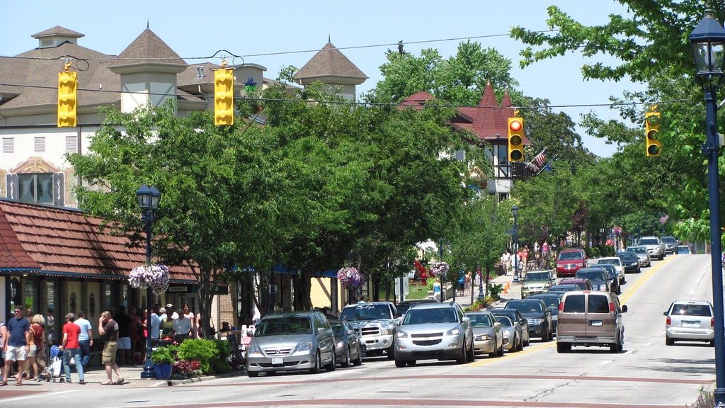 scenery of a city street with bavarian buildings and cars driving in downtown frankenmuth